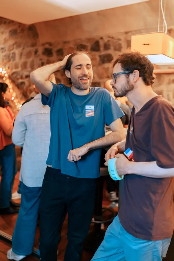 Two guests laughing together as they meet at the Social Melting Pot Thursday social in Bonn