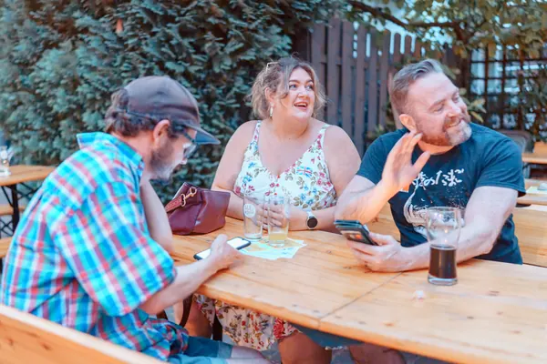 Guests laughing at a courtyard table at °Plato Beer & BBQ at the Social Melting Pot social in Bonn