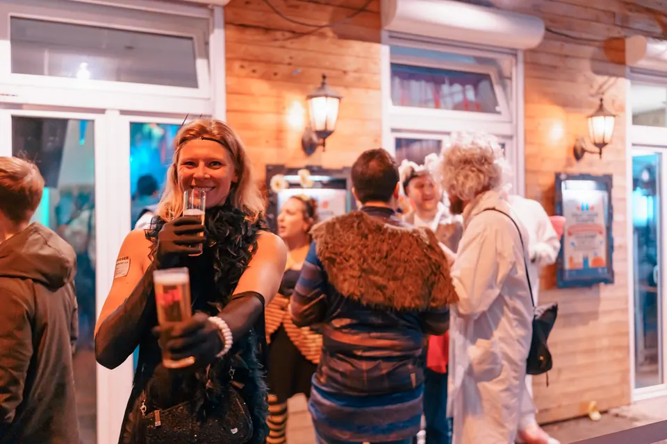 Guests in costumes toasting outside Craftbeer Corner