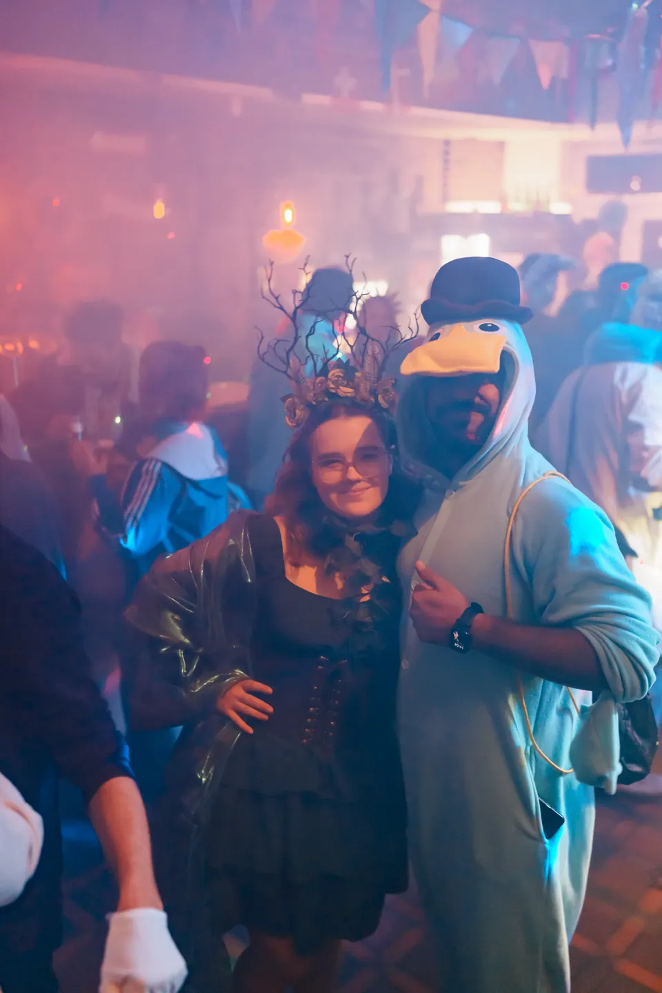 A woman with a feather headpiece and a man in a duck costume on 11.11