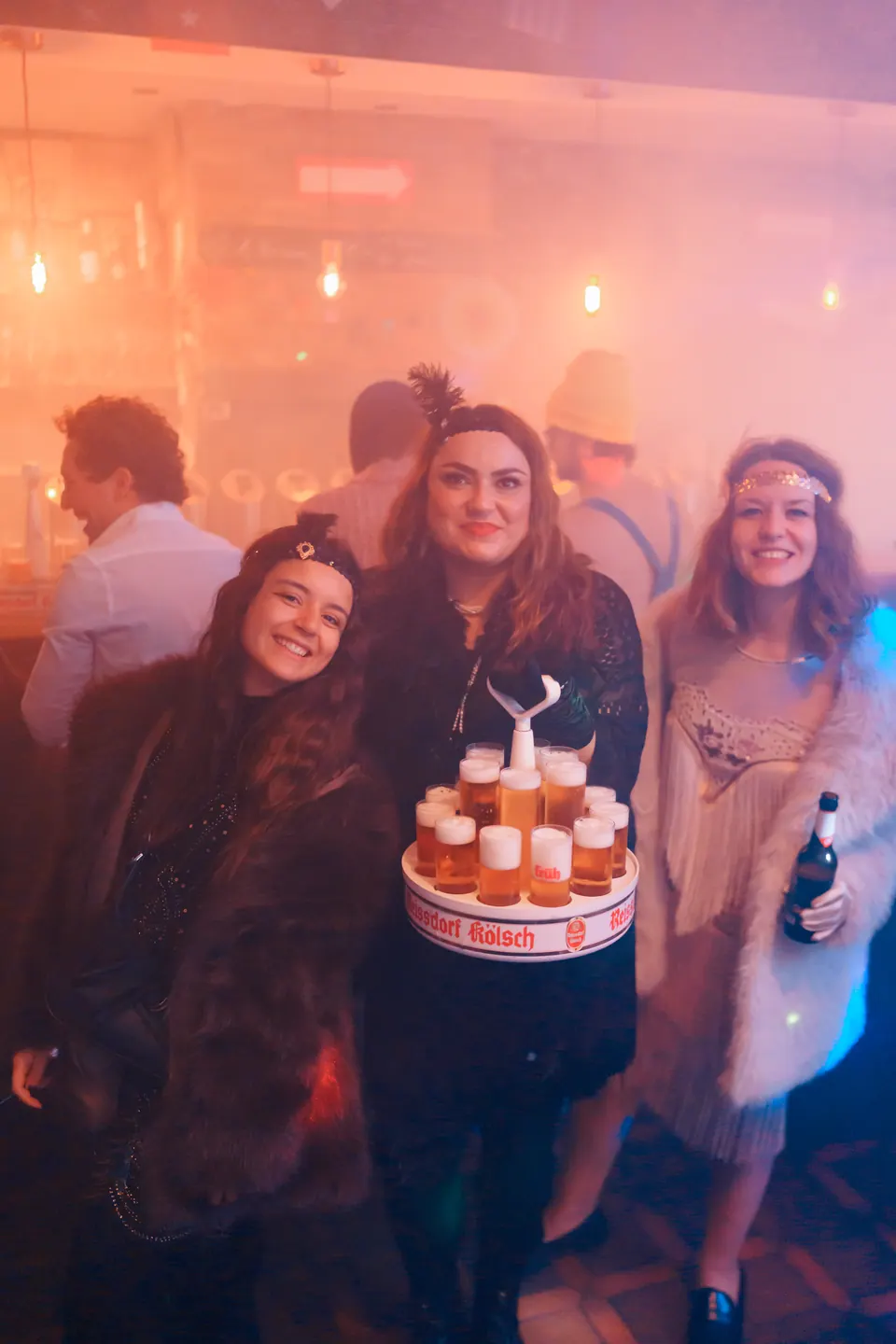 Three friends holding a K&ouml;lsch Kranz on 11.11