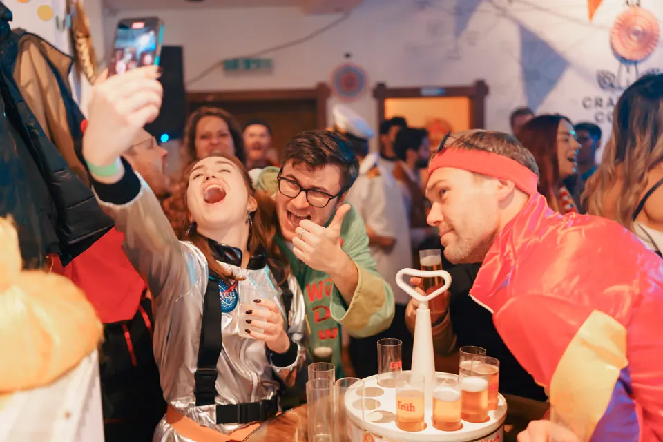 Friends toasting with K&ouml;lsch at a table on 11.11