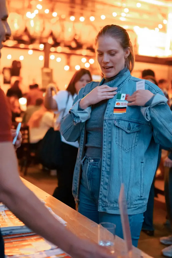 A guest pressing a language flag sticker onto her jacket at the SMP social at Brauerei Kürzer in Düsseldorf