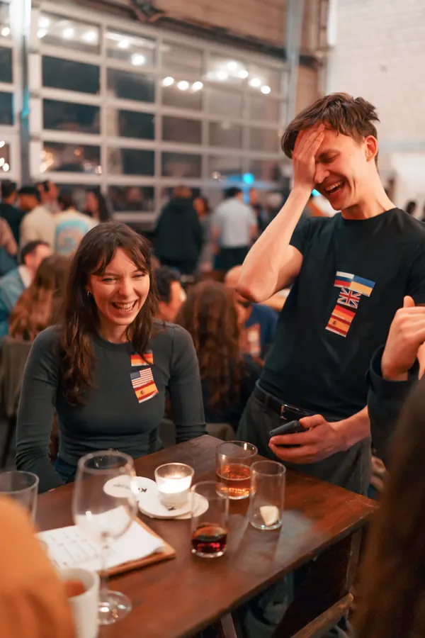 Two guests laughing out loud at a table at a Social Melting Pot Thursday night in Düsseldorf