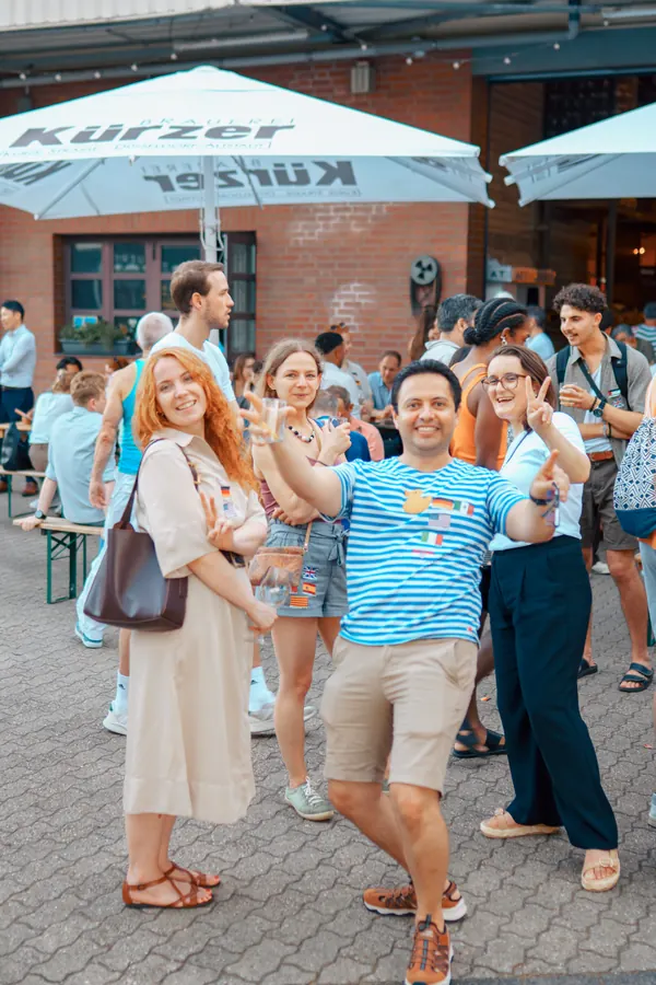 Guests dancing and laughing in the Brauerei Kürzer beer garden at the Social Melting Pot social in Düsseldorf