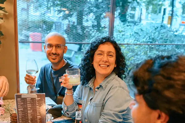 Two guests with drinks laughing together at a table at the Social Melting Pot social in Hamburg