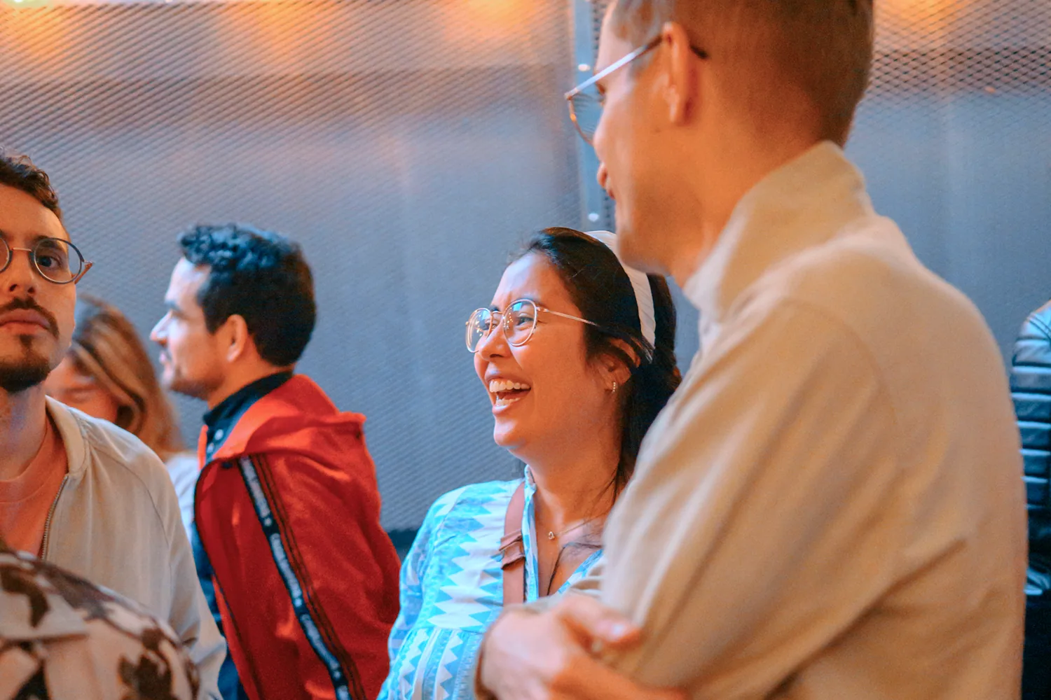 Woman laughing mid-conversation with a new acquaintance at a Hamburg social