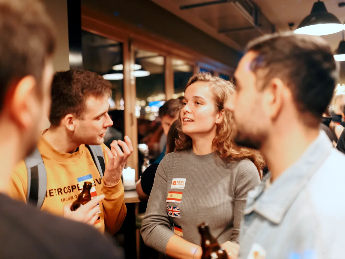 Expats talking and gesturing in a busy Hamburg bar at night
