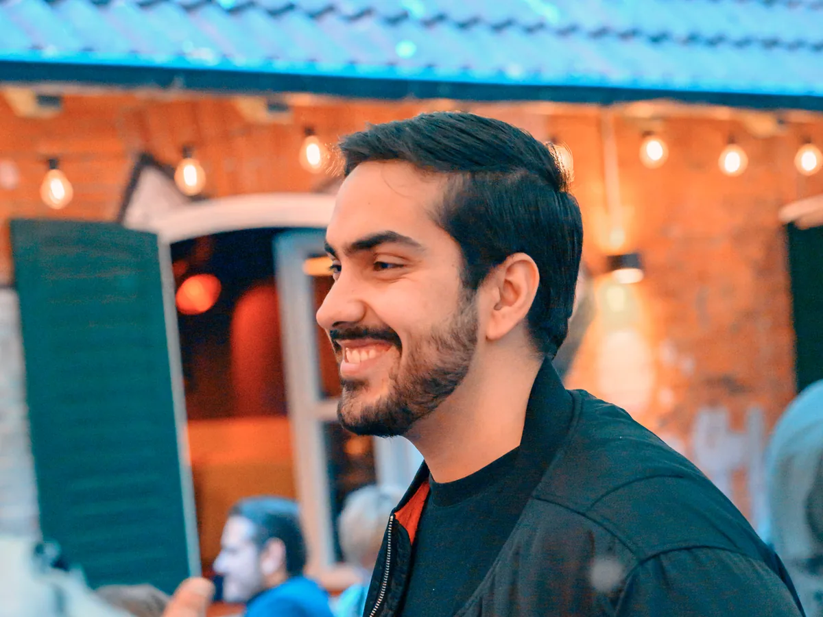 Smiling guest in conversation on a lantern-lit Hamburg terrace in the evening
