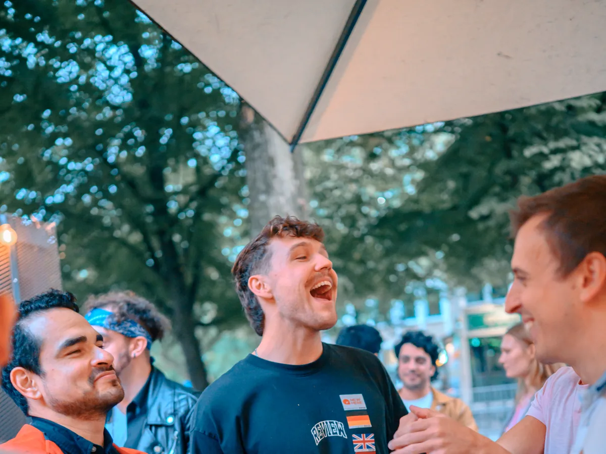 Man laughing out loud with friends on a Hamburg terrace