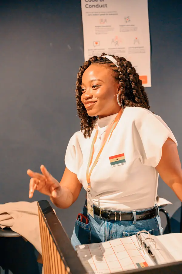 A Social Melting Pot team member at the welcome desk with the Code of Conduct sign at the social in Hamburg