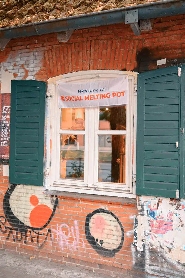 Welcome to Social Melting Pot sign in the window of Bar Grüner Jäger before the social in Hamburg