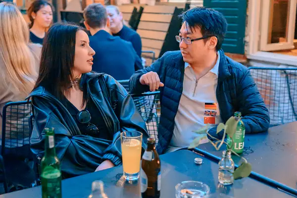 Guests with flag stickers chatting over drinks at a terrace table at Bar Grüner Jäger in Hamburg